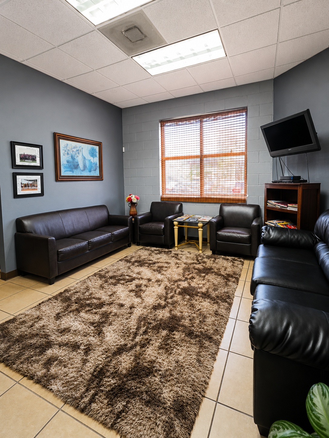 Comfortable customer waiting room with leather seating at Auto Care USA in Spring, TX