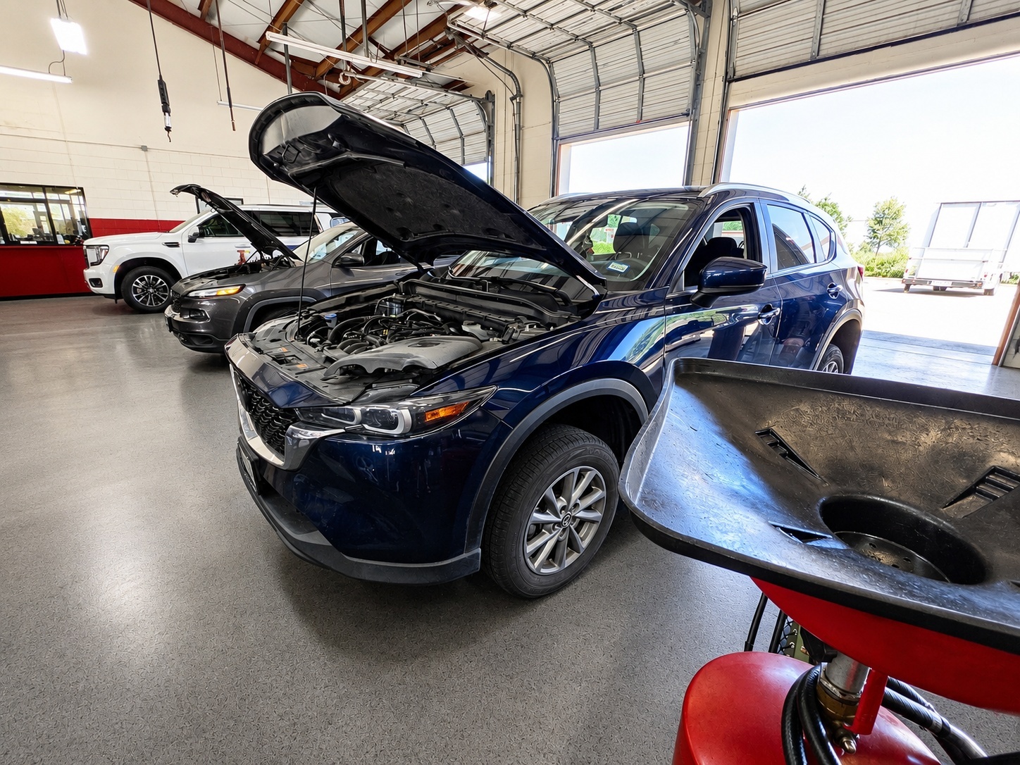 Mazda CX-5 with open hood in a service bay at Auto Care USA in Spring, TX