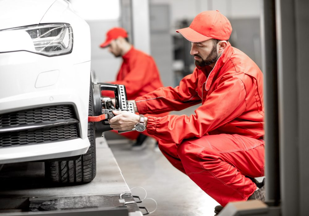 auto-mechanics-making-wheel-alignment-at-the-car-service.jpg