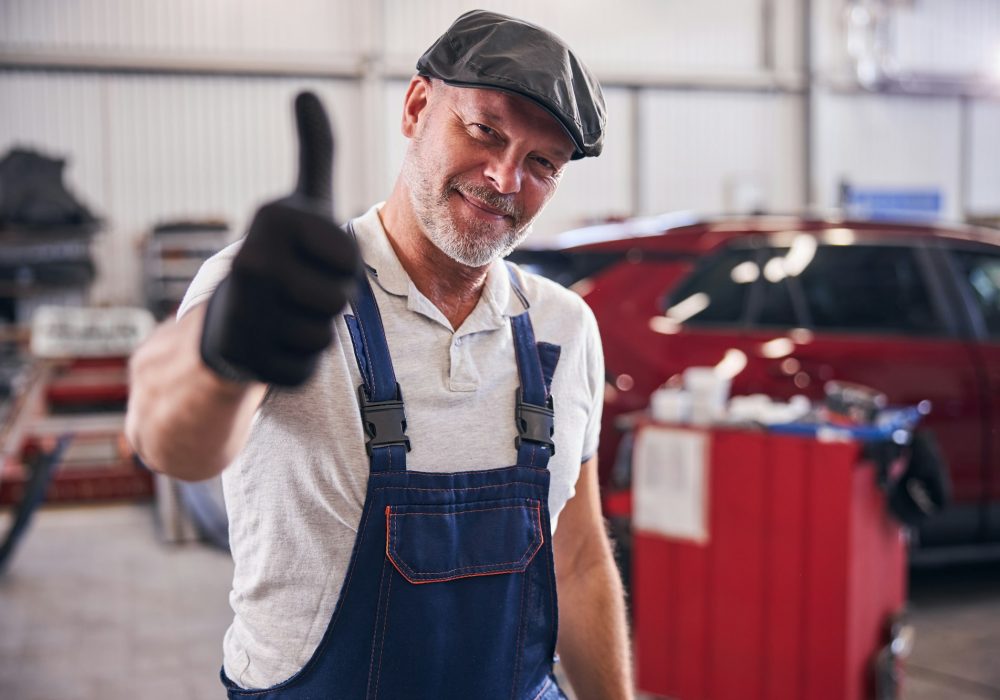 Handsome mechanic giving thumbs up and smiling