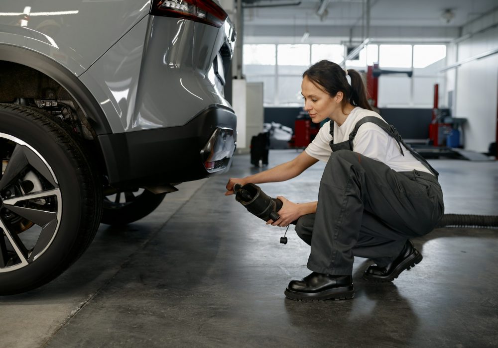 Woman mechanic testing car traffic fumes emission